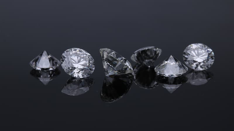 Several differently shaped diamonds laying in a dark background